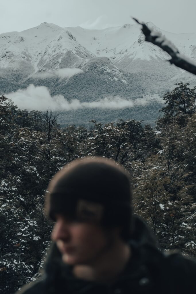 A hiker walking through a snowy mountain forest