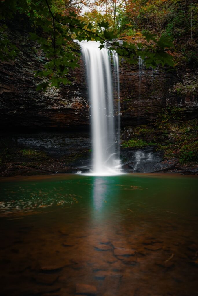 Tall waterfall surrounded by green forest in Transylvania County North Carolina